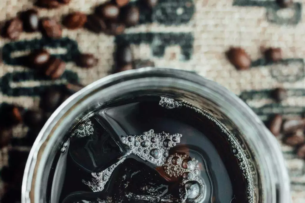 Clear cold brew coffee in a glass jar, filtered through the coffee bed using the vorlauf process